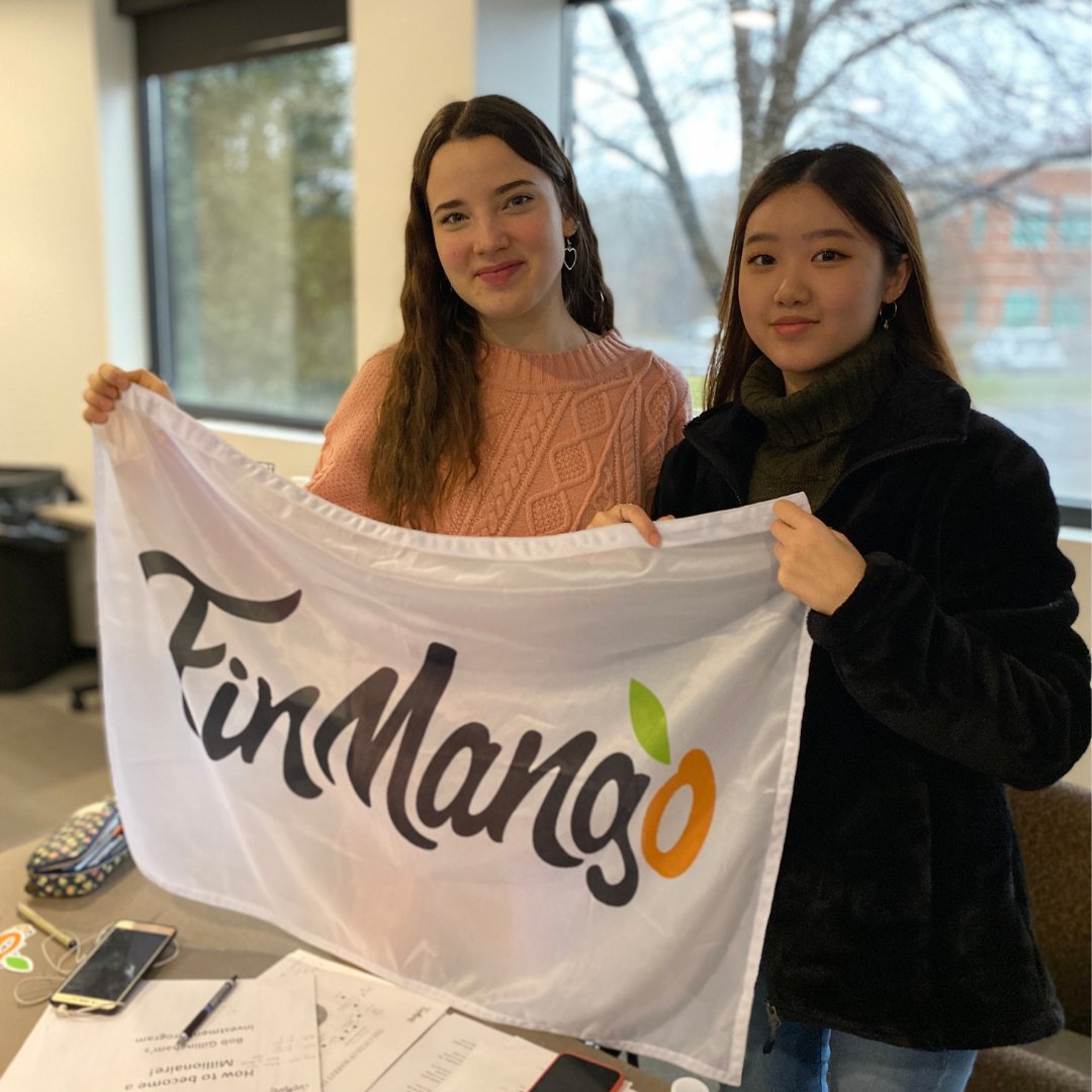 Two volunteers holding the FinMango flag at a program session
