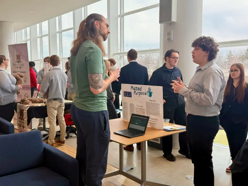 A student pitches to a judge at their table