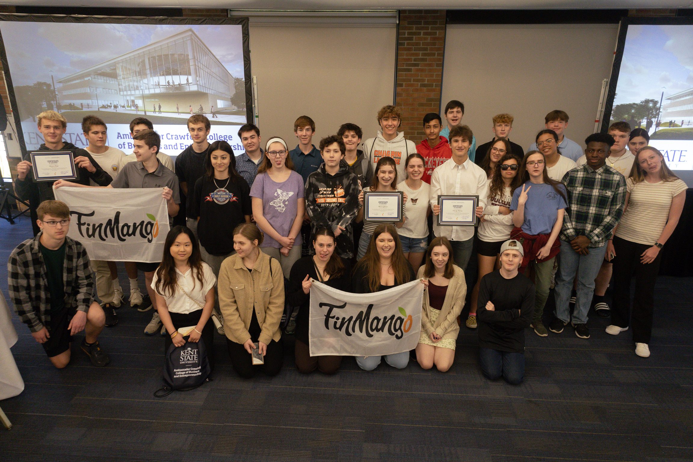 A large group of students with FinMango flags and certificates at Kent State University
